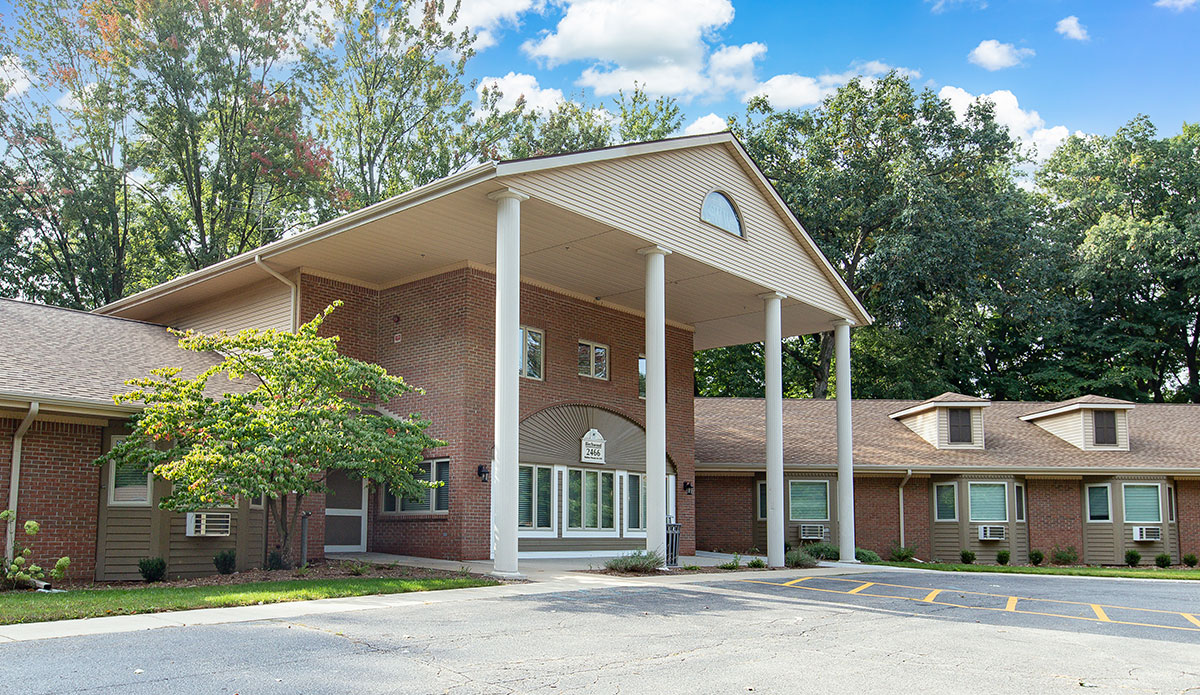 A large brick building stands next to a spacious parking lot.